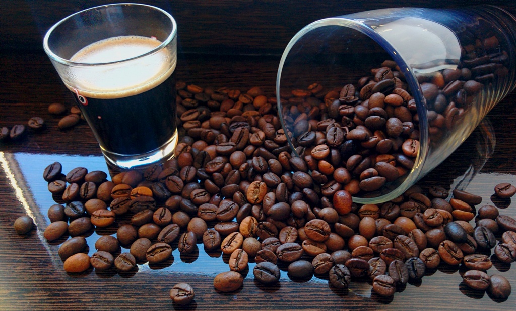 Чашка кави і кава в зернах на столі в Brayval Coffee