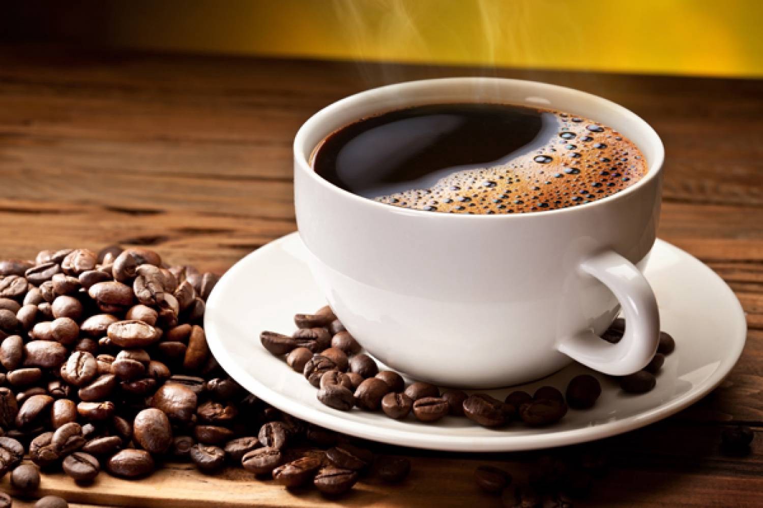 Чашка ароматної зернової кави на столі - фото.