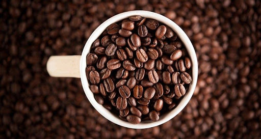 Чашка повна обсмажених кавових зерен